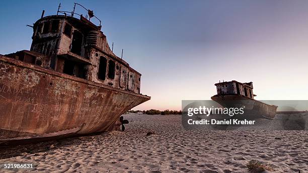 stranded ships at the port of mo?ynoq or muinak, aral sea, karakalpakstan, uzbekistan - wrak stock-fotos und bilder