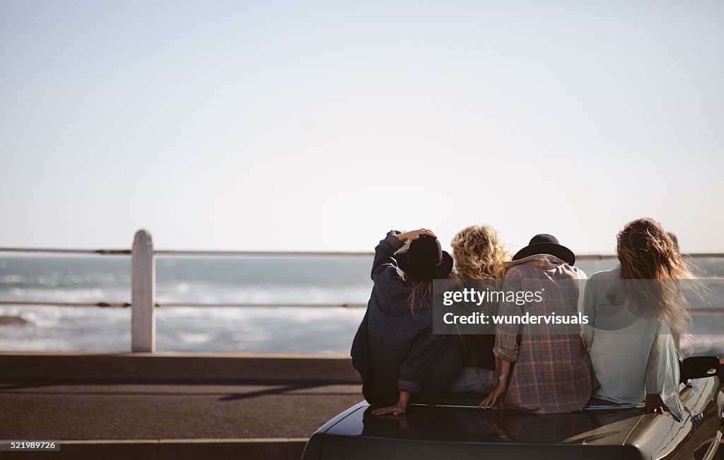 Teenager hipster styled friends watching the sea from their conv