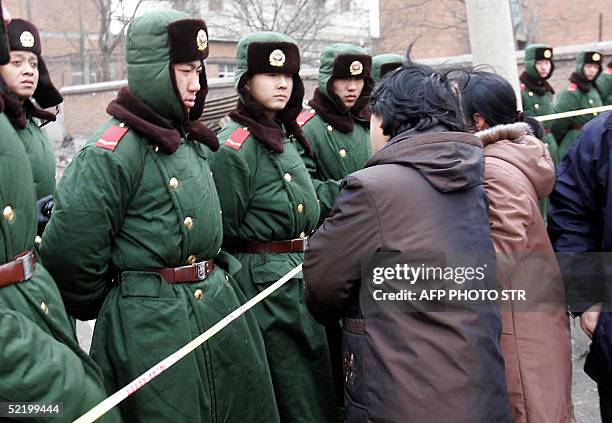 Family members of the miners try to enquire about their fate, from the Chinese paramilitary policemen guarding the entrance to the state-owned...