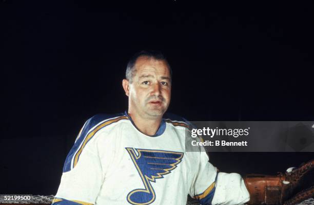 Publicity portrait of Canadian ice hockey player Glenn Hall of the St. Louis Blues as he leans against the net, 1960s.