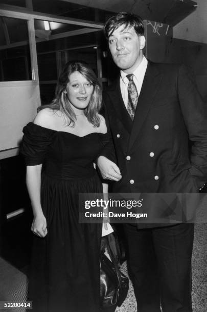 English comic Stephen Fry with a young woman on his arm, possibly his younger sister Jo, 1989.