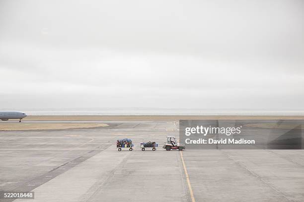 baggage wagons and plane on airport runway, auckland, north island, new zealand - pista di atterraggio foto e immagini stock