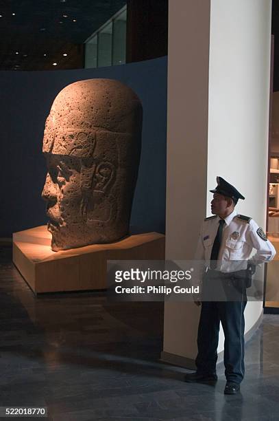 museum guard protecting stone sculpture - museo nacional de antropologia stockfoto's en -beelden
