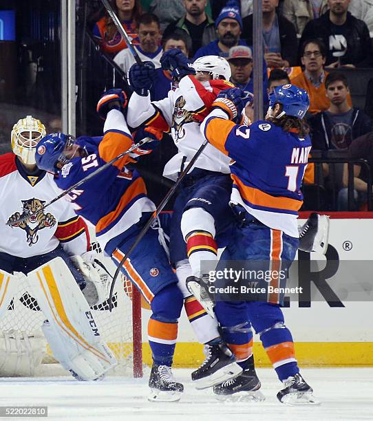 Cal Clutterbuck and Matt Martin of the New York Islanders go up against Dmitry Kulikov of the Florida Panthers during the first period during Game...