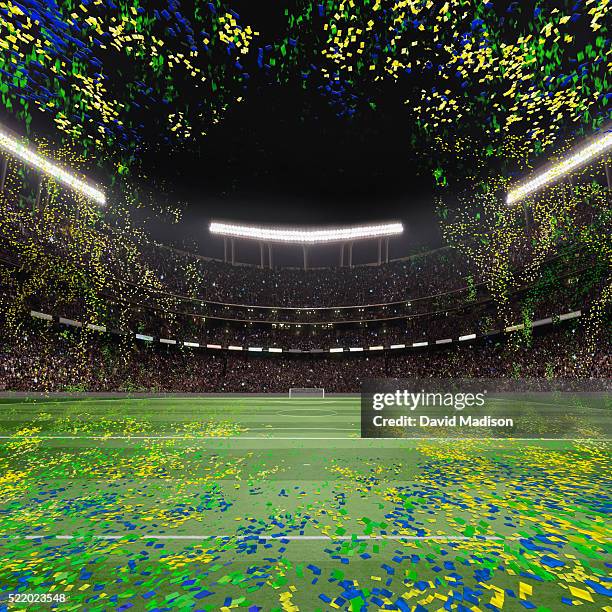 view of soccer field, goal and stadium with confetti in sky - football field stock photos et images de collection