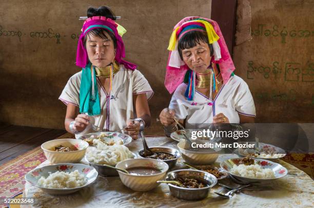 giraffe women eating traditional food - padaung tribe stock pictures, royalty-free photos & images