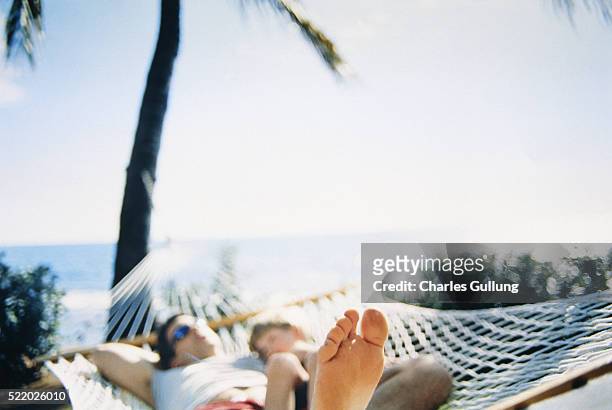 father and son relaxing in hammock - pazifikinseln stock-fotos und bilder