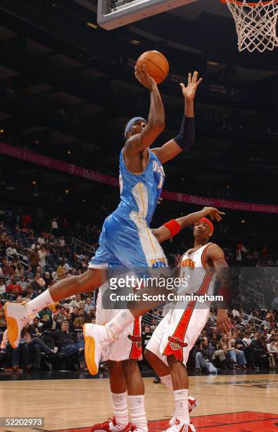 Carmelo Anthony of the Denver Nuggets goes up for a shot against Josh Smith of the Atlanta Hawks on February 15, 2005 at Philips Arena in Atlanta,...