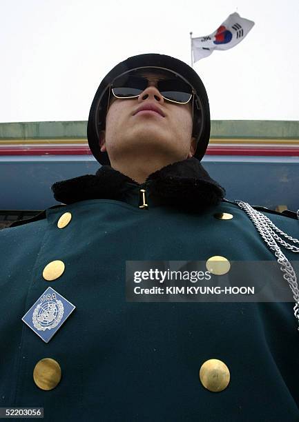 South Korean soldier stands guards in front of the national flag at Taesungdong Elementary School during a graduation ceremony for two students in...