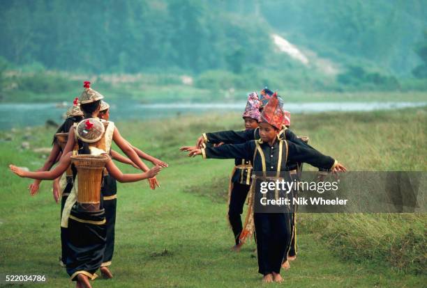 Young boys and girls from the Dusun tribe dressed in matching black silk outfits wearing baskets on their back perform the Dusun Harvest Dance,...