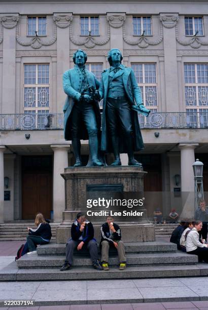 teenagers lounging by goethe and schiller sculpture - weimar foto e immagini stock