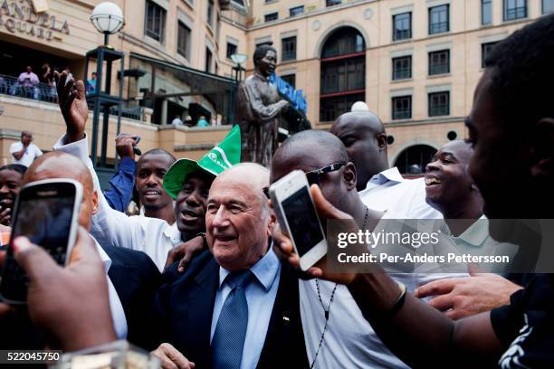 President Sepp Blatter is surrounded by fans when he visited Nelson Mandela Square, an upmarket shopping mall on February 10, 2013 in Sandton,...