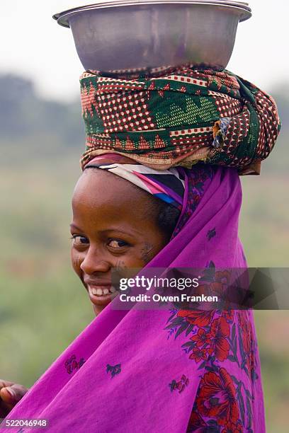 fulani woman balancing basin on her head after going to the market - futa stockfoto's en -beelden