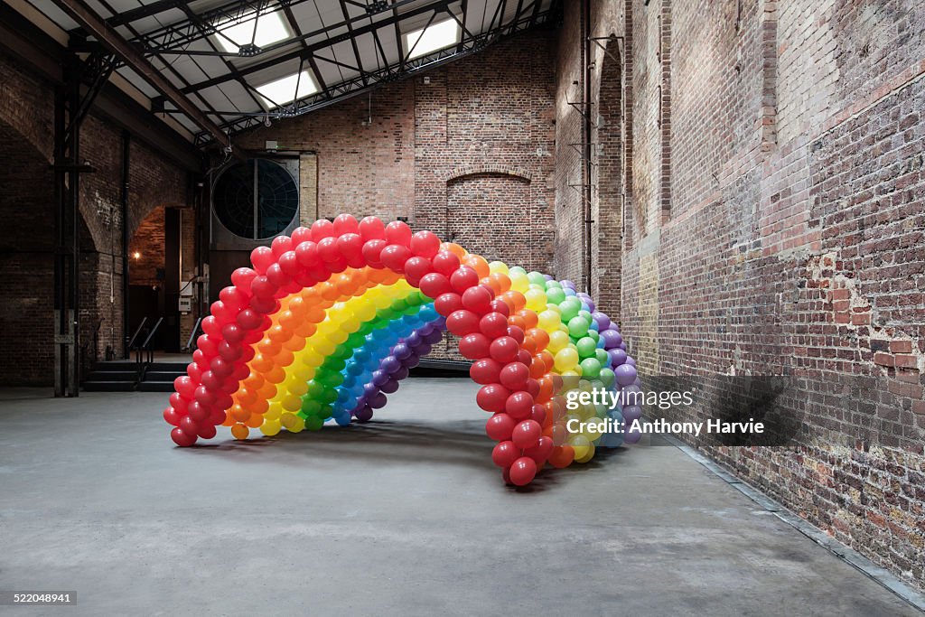 Empty warehouse with rainbow made of balloons