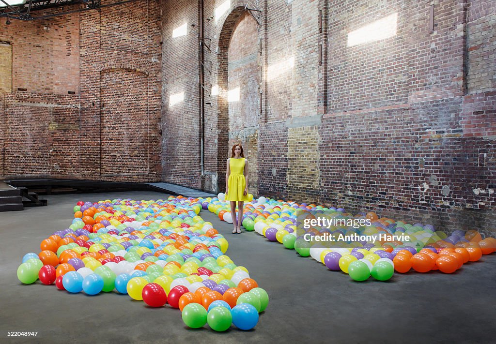 Woman in warehouse with colourful balloons