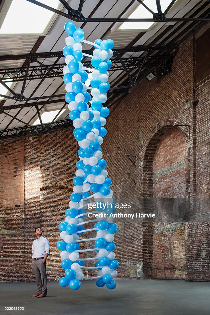 Man in warehouse with DNA made of balloons