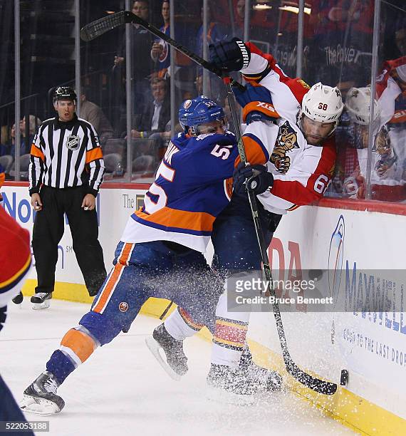 Johnny Boychuk of the New York Islanders checks Jaromir Jagr of the Florida Panthers into the boards during the third period during Game Three of the...