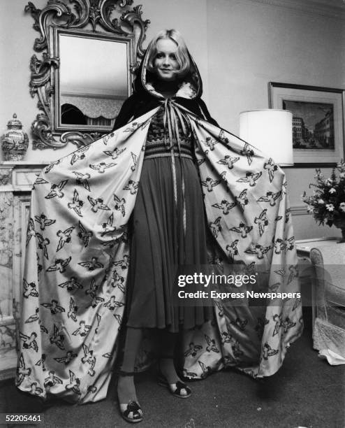 British model and actress Twiggy shows off the hooded velvet cloak with the bird lining that she will wear to the American premiere of her new film...