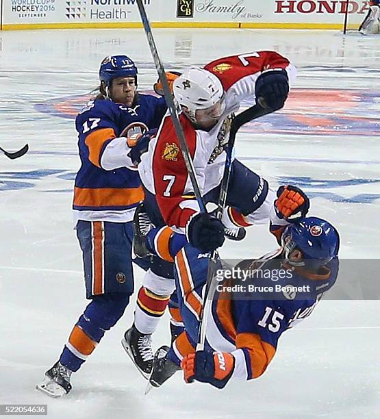 Cal Clutterbuck and Matt Martin of the New York Islanders go up against Dmitry Kulikov of the Florida Panthers during the first period during Game...