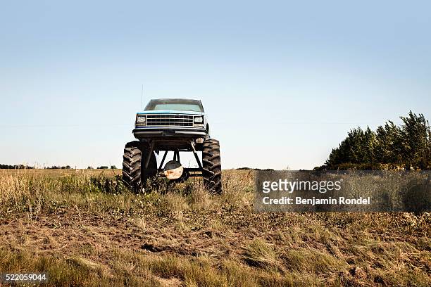 monster truck in a field - monster trucks stock pictures, royalty-free photos & images