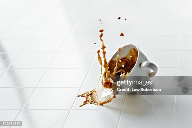 coffee cup in mid air with coffee spilling - derramar fotografías e imágenes de stock