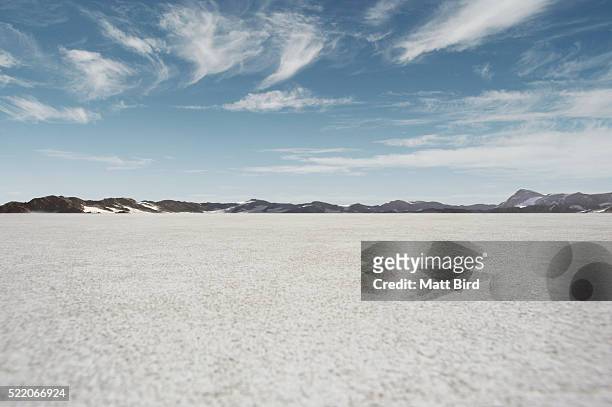 salt flat landscape with blue sky and mountains - lago salato foto e immagini stock