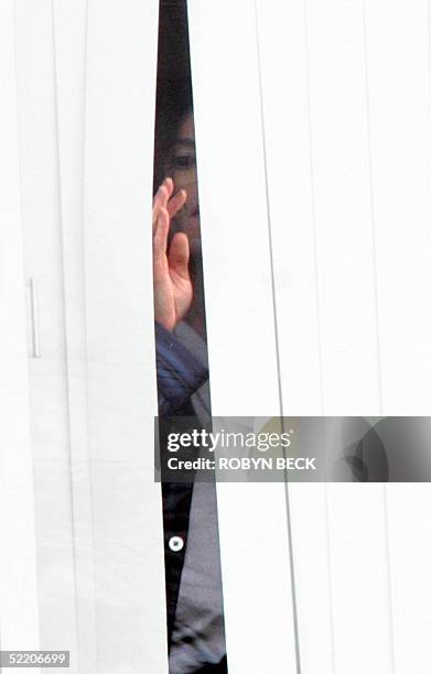 Pop star Michael Jackson waves from his room on the fourth floor of the Marian Medical Center in Santa Maria, CA, 16 February 2005, where he stayed...