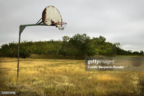 old basketball hoop in field - vintage basketball court stock pictures, royalty-free photos & images