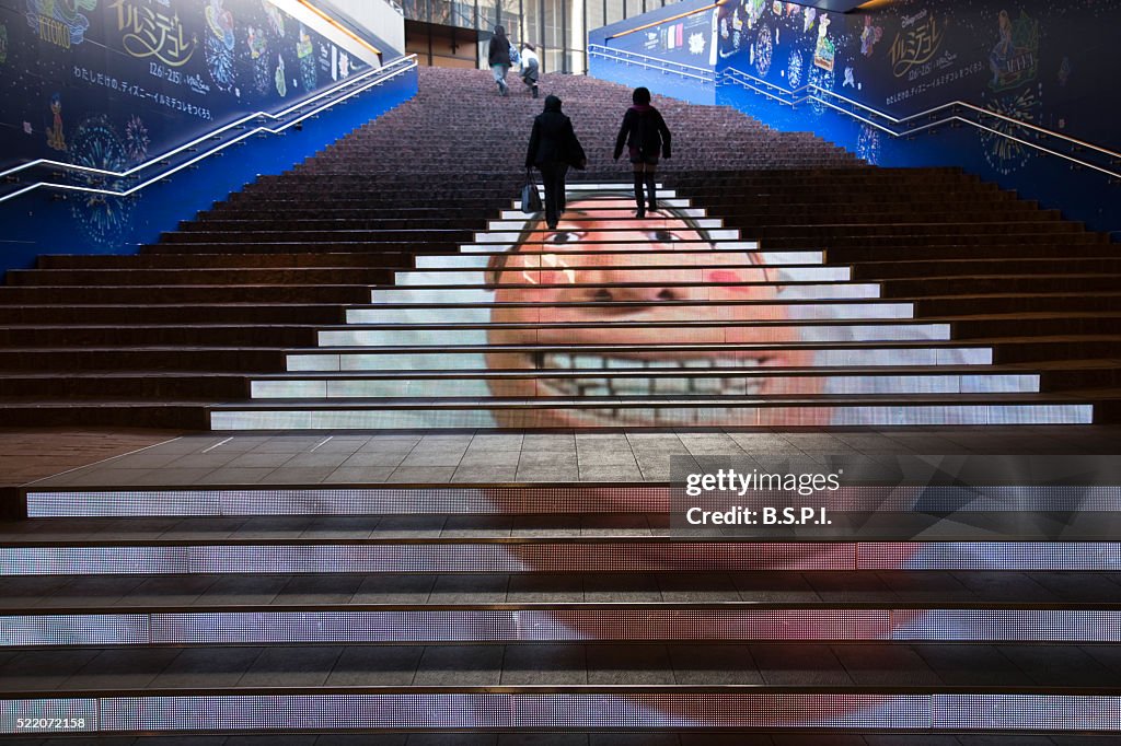 People climb the electronically-illustrated steps leading up from Akasaka Station to TBS TV Headquarters in the Akasaka District of central Tokyo, Japan