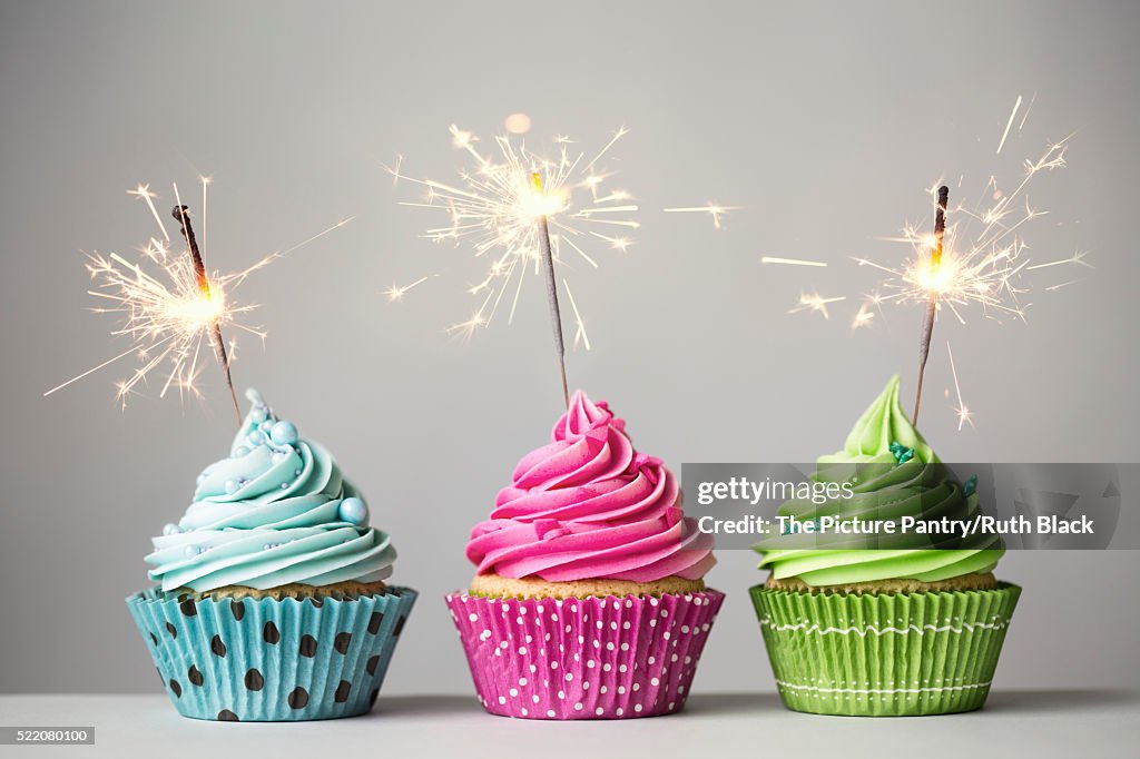 Three cupcakes with sparklers