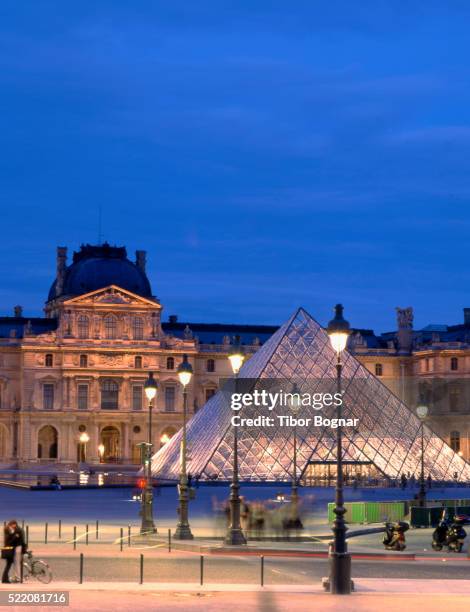 pyramid entrance to louvre at dusk - louvre pyramid stock pictures, royalty-free photos & images