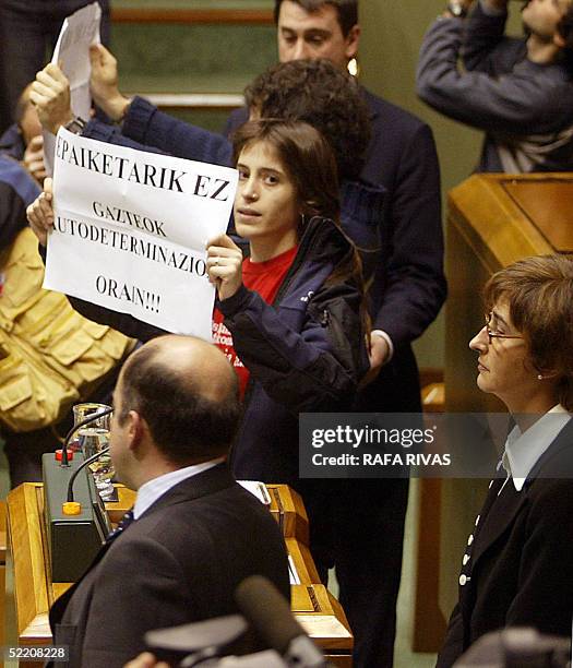 Basque government vice president Idoia Zenarruzabeitia stops addressing the Parliament as she is interrupted by two unidentified persons showing...