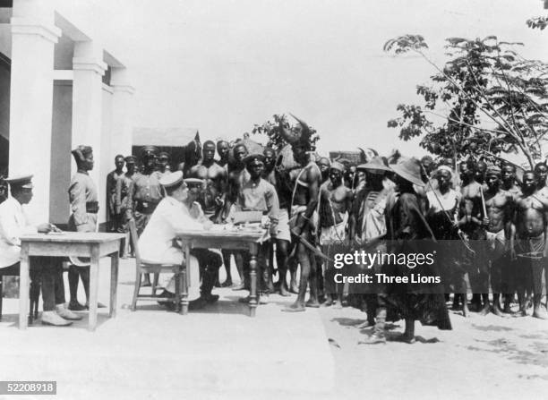 Togolese men, in traditional dress, are recruited into the army in German-controlled Togoland, circa 1914.