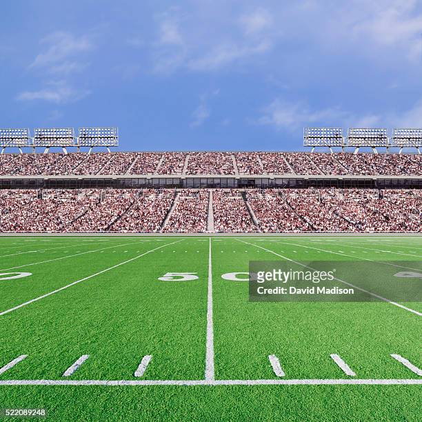 american football stadium with empty field and crowd - bleachers stock-fotos und bilder
