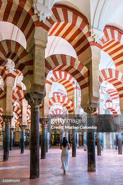 woman walking inside the mezquita of cordoba - cordoba mosque stock-fotos und bilder