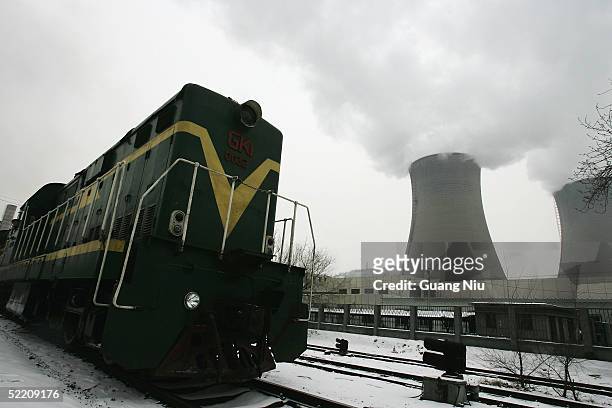 Train passes the giant cooling towers of a power station on February 17, 2005 in Beijing, China. China, the world's second biggest greenhouse gas...