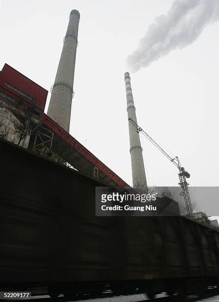 Train passes the giant chimneys of a power station on February 17, 2005 in Beijing, China. China, the world's second biggest greenhouse gas emitter...