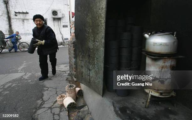 An elderly woman carries some heating coal on February 17, 2005 in Beijing, China. China, the world's second biggest greenhouse gas emitter after the...