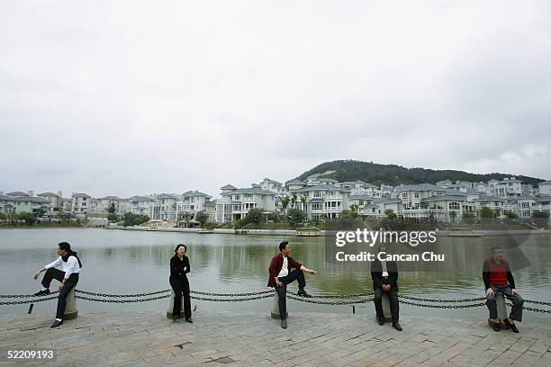 Chinese people rest beside a lake at a luxury residential area on February 15, 2005 in Jiangmen, Guangdong Province, China. The luxury real estate...