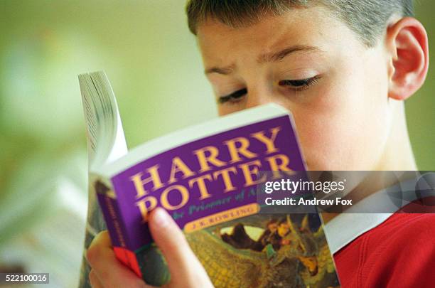 boy reading harry potter - harry potter kunstwerkname stock-fotos und bilder