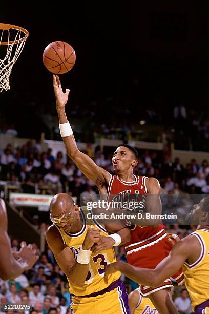 Scottie Pippen of the Chicago Bulls drives to the basket for a layup against Kareem Abdul-Jabbar of the Los Angeles Lakers during an NBA game circa...