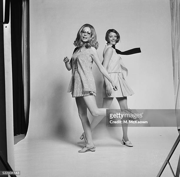 Models Sally Steward wearing a printed dacron and cotton playsuit with pleated culotte skirt with matching cover up by Carnegie and Suzy Kidd wearing...