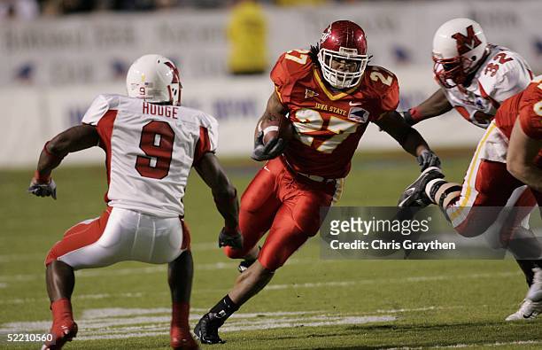 Running back Stevie Hicks of the Iowa State University Cyclones evades defensive back Alphonso Hodge and linebacker Terna Nande of the Miami...