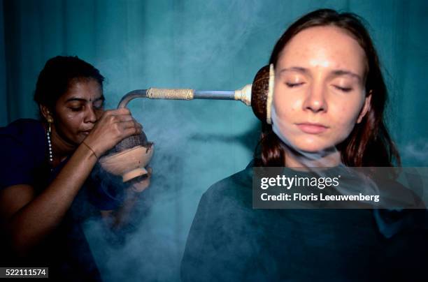 blowing medicinal steam in ear - ayurveda kerala stock pictures, royalty-free photos & images