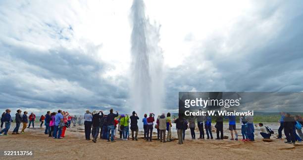 tourists watching the eruption of the geysir "strokkur" - strokkur stock pictures, royalty-free photos & images