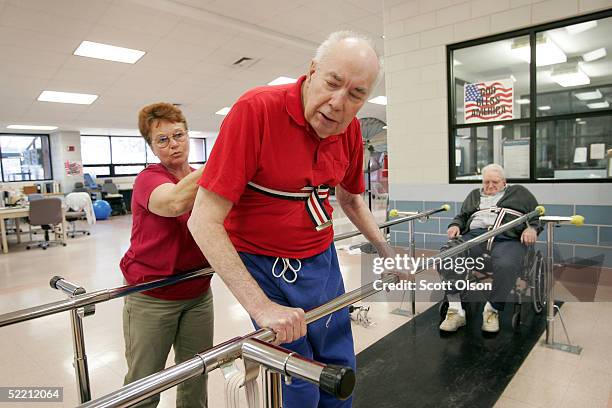 Shirley Gooding , a physical therapy aid, helps William Rexroat , a World War II Navy veteran, exercise during a therapy session as Charles Melvin...