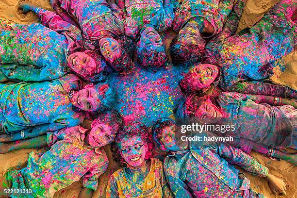 grupo de crianças felizes jogando holi indiana, deserto village, india - holi - fotografias e filmes do acervo