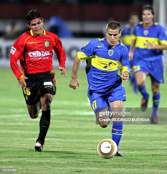 Rodrigo Palacio de Boca Juniors de Argentina conduce el balon ante la presion de Geancarlo Ramos del Deportivo Cuenca de Ecuador durante el partido...