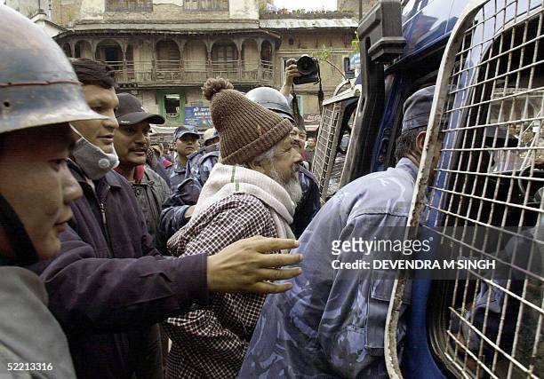 Nepalese riot policemen push into a police van an activist during a demonstration staged by opposition political parties and students in defiance to...