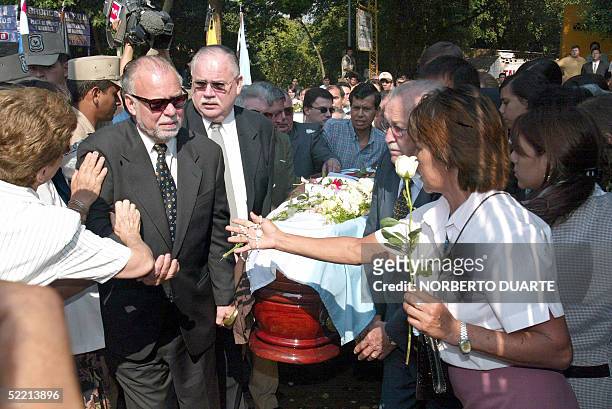 Former Paraguayan President Raul Cubas receives condolences as he arrives at the cemetery carrying the coffin of his daughter Cecilia Cubas, in...